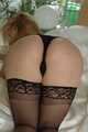 Pierced blonde Nina posing in lingerie and stockings on bed 8