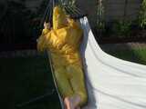 Watch Chloe enjoying the warm Sun in her yellow shiny nylon Rainsuit  10