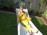 Watch Chloe enjoying the warm Sun in her yellow shiny nylon Rainsuit  6